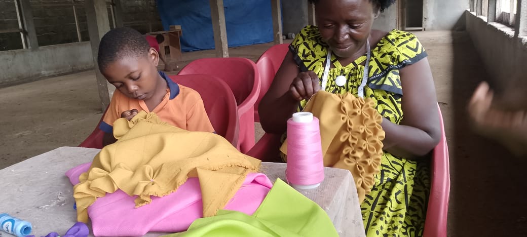 Formatrice accompagnant un enfant pendant l'atelier de couture